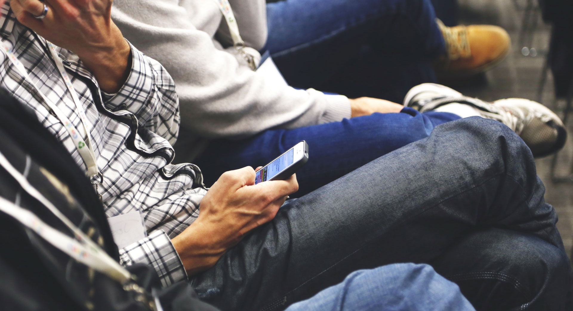 people sitting cross legged at event with phone in hand