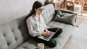 woman sitting on sofa with laptop