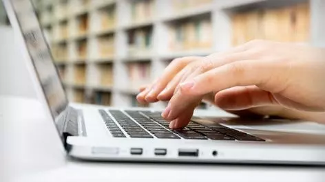 hands typing on laptop keyboard